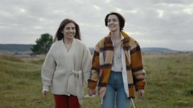 İki lezbiyen gülümsüyor ve temiz havada konuşuyor.