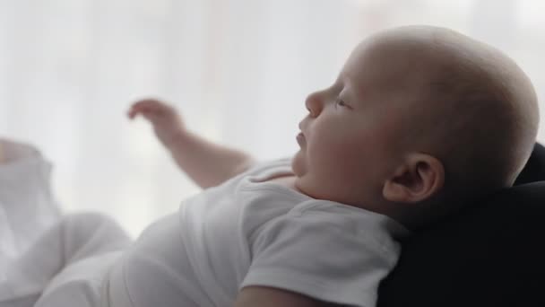 Glückliches entzückendes Baby, das auf den Händen der Mutter liegt — Stockvideo