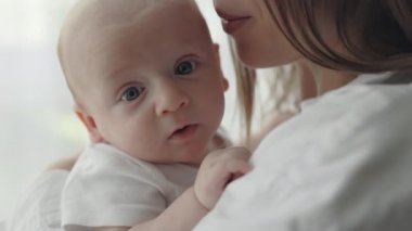 Annenin, güzel oğlunun elini tutup şarkı söylediği yakın plan.