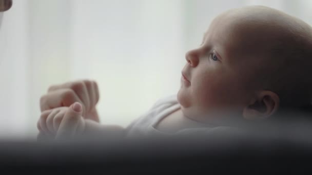 Крупним планом маленький новонароджений хлопчик посміхається матері — стокове відео