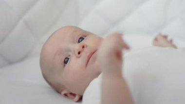 Sevimli küçük çocuk rahat bir yatakta tek başına yatıyor.