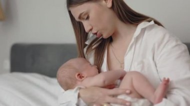 Anne kucağında ağlayan yeni doğan oğlunu okşuyor.