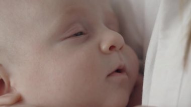 Annesinin ellerinde tatlı tatlı uyuyan şirin bebeğe yakın.