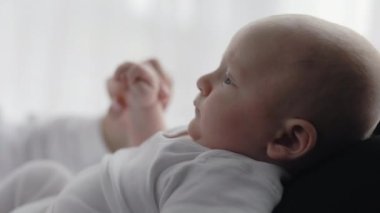 Sevimli, yeni doğmuş çocuk, şefkatli anne ellerinde yatıyor.