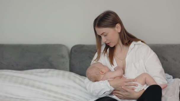 Happy mother rocking baby son in her arms — Stockvideo