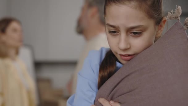Близький Погляд Сумну Дівчинку Яка Тримає Подушку Слухаючи Батьків Сперечаються — стокове відео