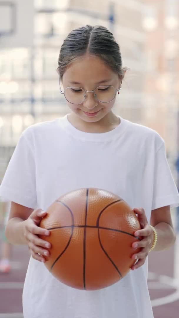 Vertical Video Poprtrait Asian Schoolgirl Standing Basketball Court Holding Ball — Vídeo de stock
