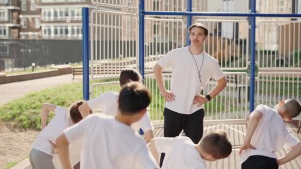 School Kids Exercise Sport Class Teacher Outdoor Coach Shows How — Vídeo de stock
