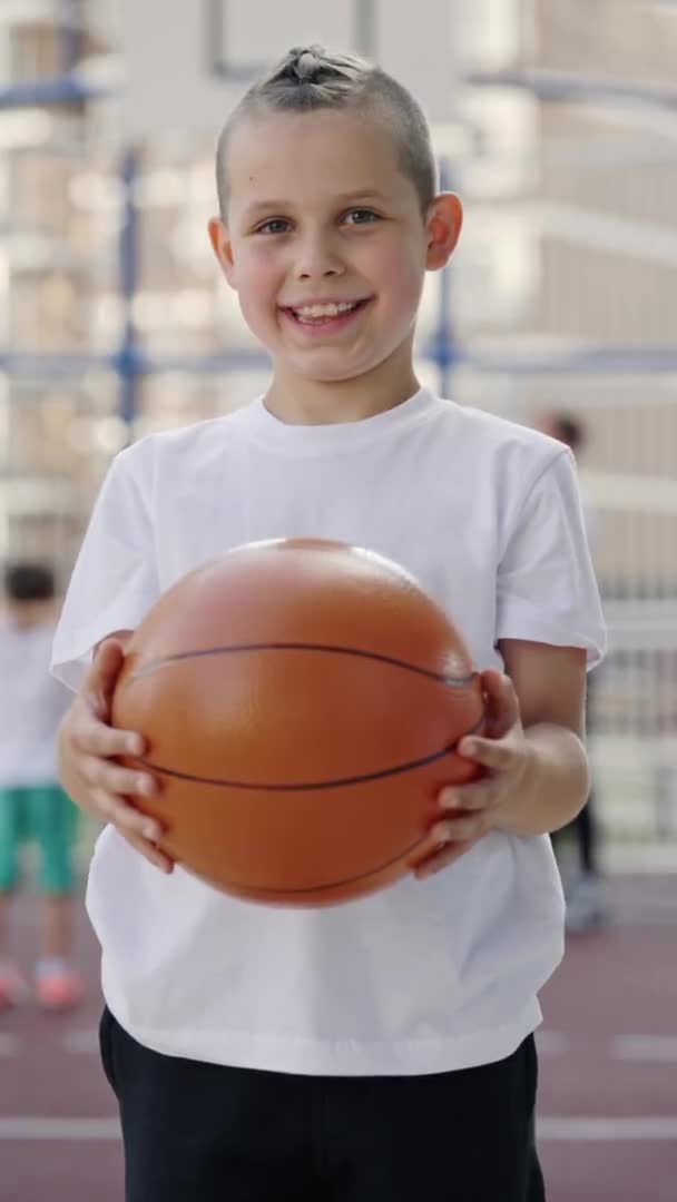 Vertical Video Portrait Little Schoolboy Standing Court Holding Ball Looking — Vídeos de Stock