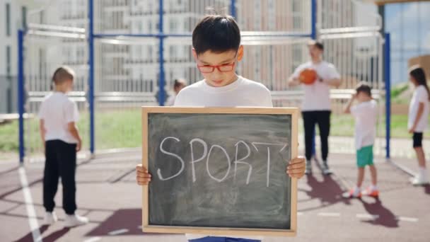 Portrait Little Asian Boy Holding Board Sport Raising His Head — стоковое видео