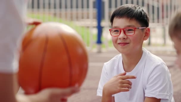 Mały Chłopiec Patrząc Słuchając Zasad Gry Koszykówkę Azjata Okularach Zgadza — Wideo stockowe