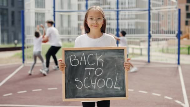 Portrait Asian Girl Standing Basketball Court Raising Schoolboard Text Back — стоковое видео