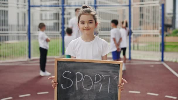 Portrait Little Cute School Girl Standing Holding Chalkboard Sport Looking — ストック動画