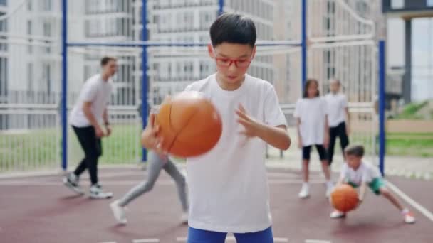 Asian Schoolboy Glasses Catching Ball Basketball Court Street Smilling Sport — Vídeo de stock