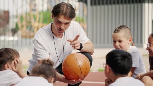 Sporty Coach Catching Ball Explaining Game Strategy Primary School Children — Stock video