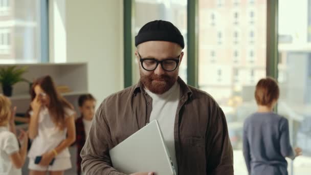 Портрет Улыбающегося Учителя Мужского Пола Стоящего Классе Ноутбуком Очках Шляпе — стоковое видео
