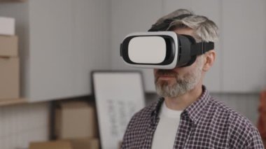 Close view of the man has put on vr technology and estimates the apartment already furnished. Man using virtual reality for seeing his new apartment already furnished. Technologies and future concept