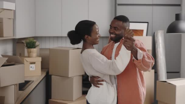 アフリカ系アメリカ人の笑顔のカップルたちが一緒に幸せを感じて新しい家で踊る 家族関係 移転および不動産の概念 — ストック動画