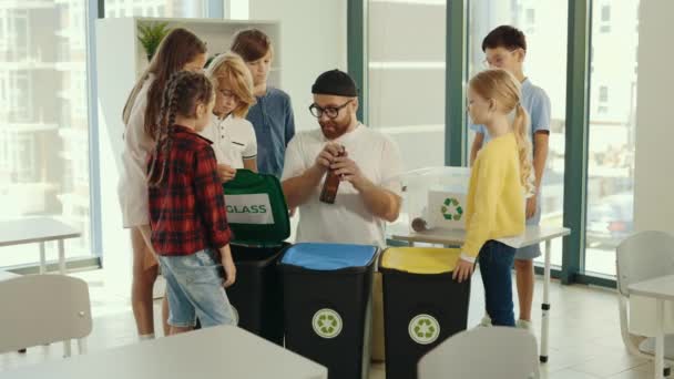 男教师向学生展示正确分类垃圾的方法和地点 并与学生一起在垃圾分类课上对垃圾进行分类 生态课 Bsck去学校 — 图库视频影像