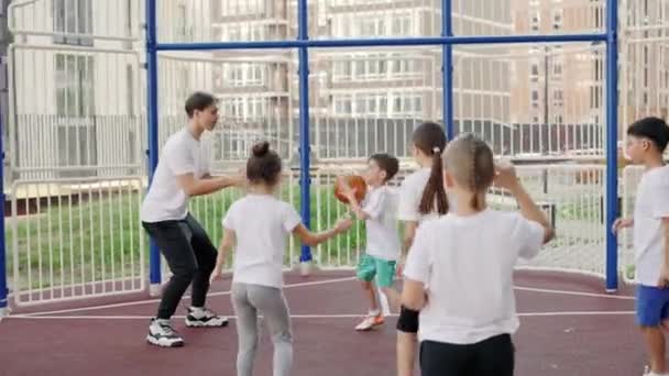 Nauczyciel Sportu Trenuje Samce Uczniów Podczas Szkolnego Meczu Koszykówki Boisku — Wideo stockowe