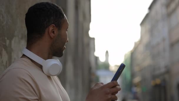 Близький Погляд Усміхненого Афроамериканця Який Використовує Смартфон Стоїть Старій Вулиці — стокове відео