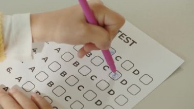 Sınav. Cevapları dolduran bir kız öğrencinin ellerini kapat. Sınıftaki masanın üzerinde test yapan çocuklar. Halk ve eğitim kavramı
