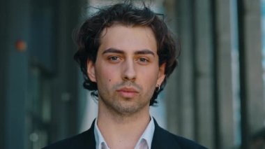 İş merkezinin yanında duran beyaz işadamının portresi. Siyah kostüm giymiş kameraya bakıyor. Erkek patron iş yerinin yakınında kameraya bakıyor.
