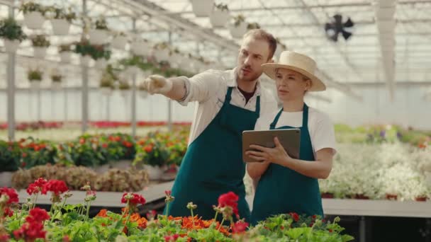 Κηπουροί Χρησιμοποιούν Μια Ψηφιακή Ταμπλέτα Για Εργασία Αρσενικός Κηπουρός Δείχνει — Αρχείο Βίντεο