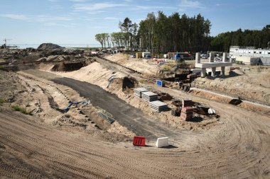 Bir inşaat sahasında çalışan makineler ve Polonya 'da çalışırken bir inşaat sahasında depolanan elementler.