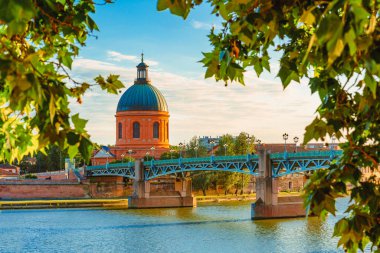 Toulouse, Fransa 'daki Garonne Nehri ve La Grave Kubbesi boyunca gün batımında canlı manzara