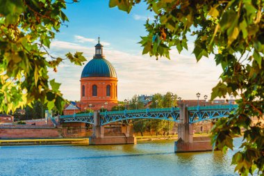 Vibrant landscape at sunset along the Garonne River and La Grave dome in Toulouse, France clipart
