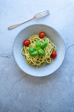 Domates soslu spagetti ve arka planda fesleğen