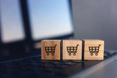 Wooden cubes with shopping cart on laptop keyboard. Online Shopping concept