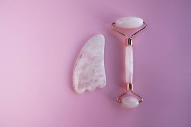 Yüz masajı seti. Yüz silindiri ve gua sha masaj aleti, doğal pembe taşlardan yapılmış, refah, yüz fitness konsepti, şık tek renkli kart, lüks afiş.
