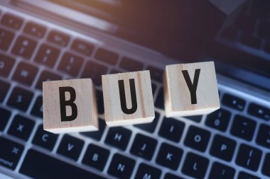 Wooden cubes with word buy on laptop keyboard. Online Shopping concept