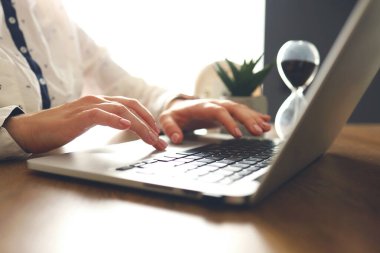 Female young hands with manicure typing text on laptop. Working with laptop at home or office. Close-up.