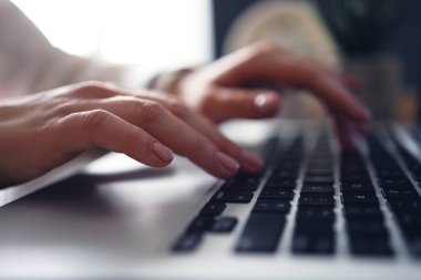 Female young hands with manicure typing text on laptop. Working with laptop at home or office. Close-up.