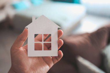 Home or house model on man hand in pastel color room background. Investment wealthy freedom life concept.