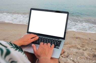 Mockup image of woman using and typing on laptop with blank desktop screen