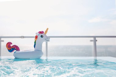 Inflatable unicorn circle in the pool on the background of the sea. Summer background.