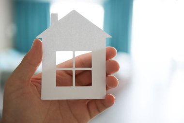 Home or house model on man hand in pastel color room background. Investment wealthy freedom life concept.