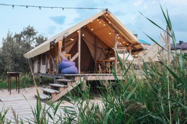 Glamping tent in the forest. Luxury tent sea view. Nature green tourism.