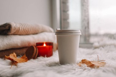 Paper cup with tea on the windowsill. Autumn mood.