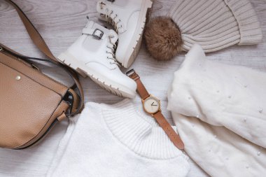 Autumn outfit with sweater, bag, hat, scarf and boots, top view of the fall winter season outfit idea with glasses and watch accessory