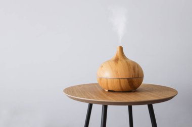 Diffuser of aromatic oil on a wooden table on a white background.