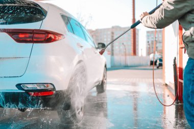 Manual car wash with pressurized water in car wash outside. Summer Car Washing. Cleaning Car Using High Pressure Water. Washing with soap. Close up concept.