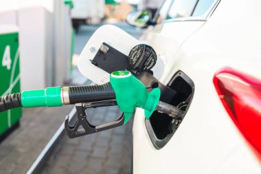 Benzin istasyonunda benzinle ya da dizel yakıtla doldurulan büyük bir SUV. Yakıt pompası pompalı tüfek.