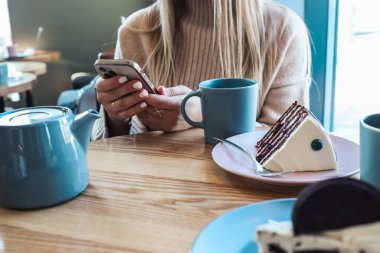 Bara yaslanmış kadın sayaç ve metin onun mobile ile mesajlaşma, eller kapat