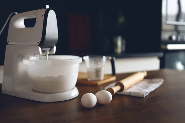 Closeup of a table in a home kitchen with a mixer and products for desserts. Preparing for the preparation of food.