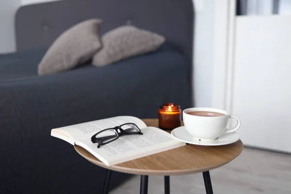 Cup of tea with books on table in room